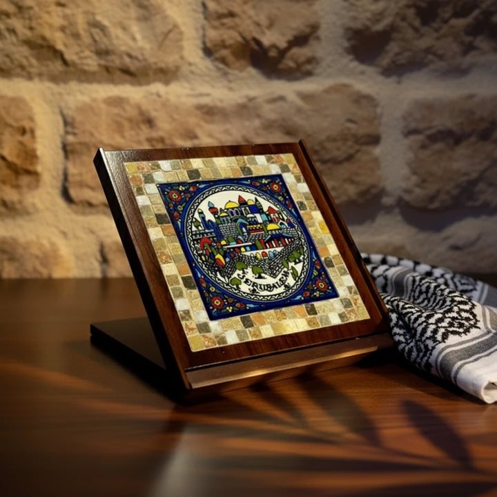 Decorative tile with mosaic design on a wooden stand against a stone wall.