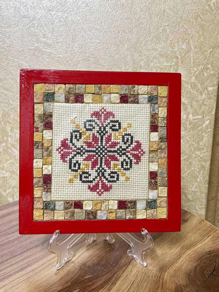 Pal-Mosaic mosaic and embroidery featuring Palestinian flower embroidery art with red frame on clear stand